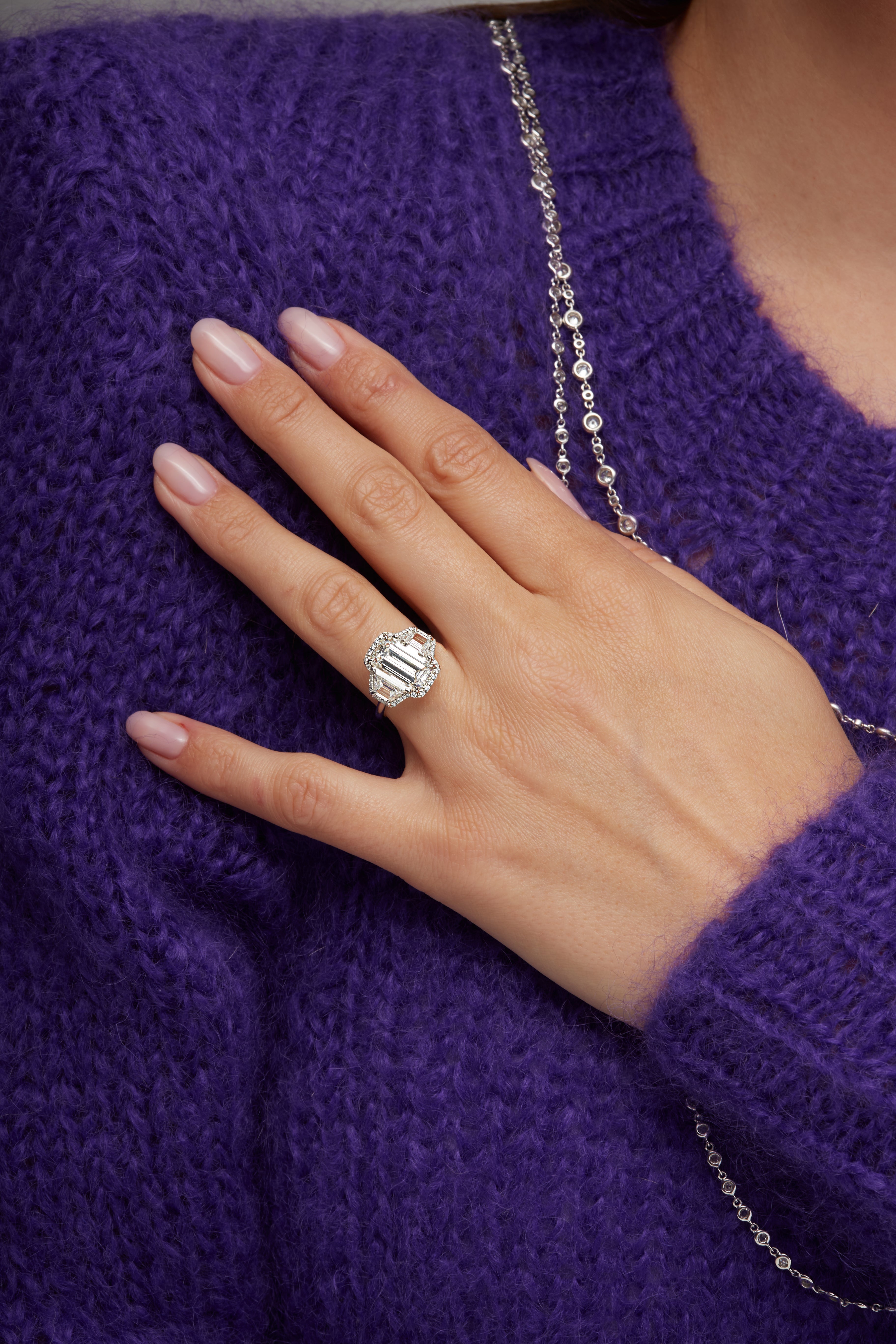 Emerald Cut Diamond and Two Trapezoid Diamonds Halo Ring