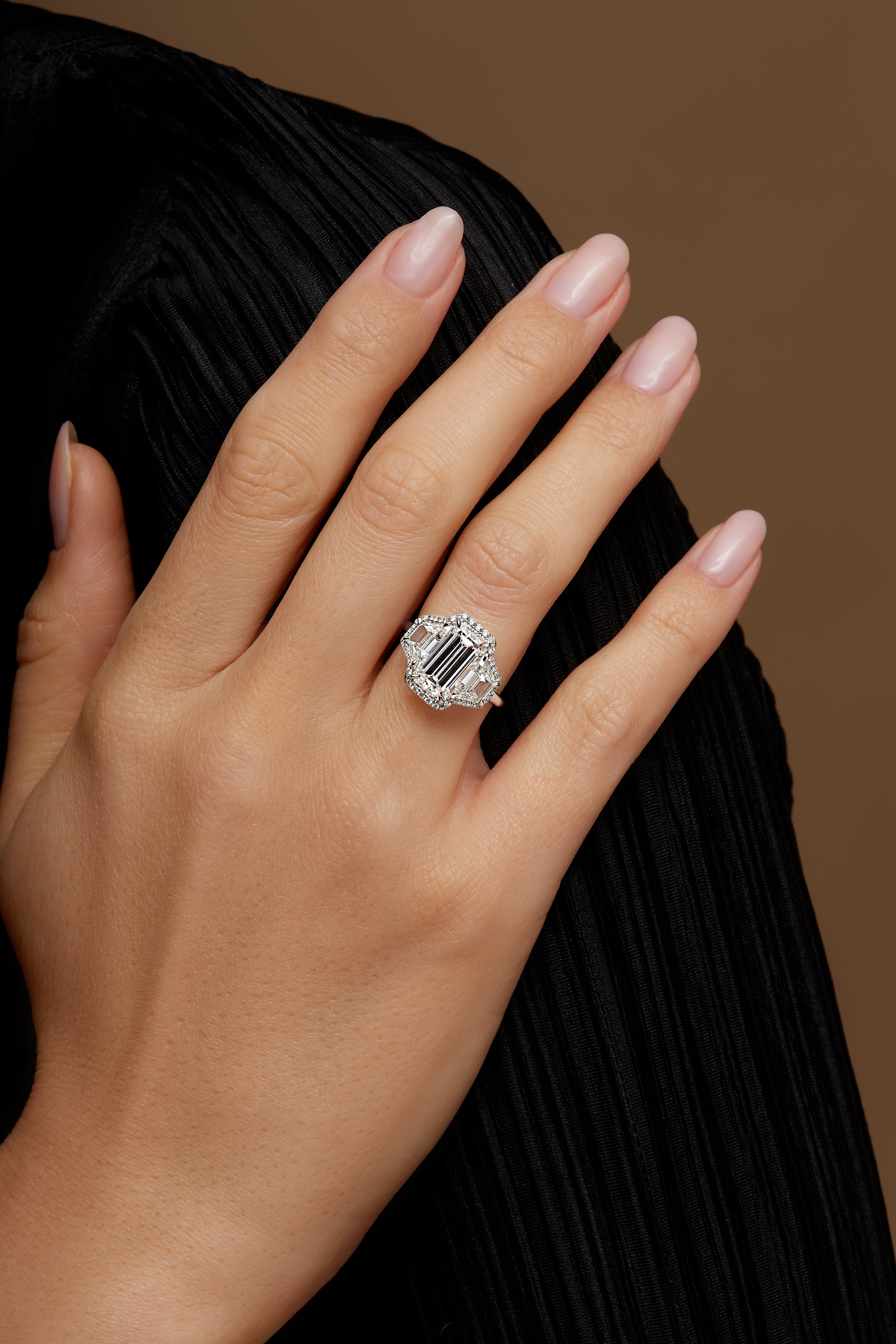 Emerald Cut Diamond and Two Trapezoid Diamonds Halo Ring