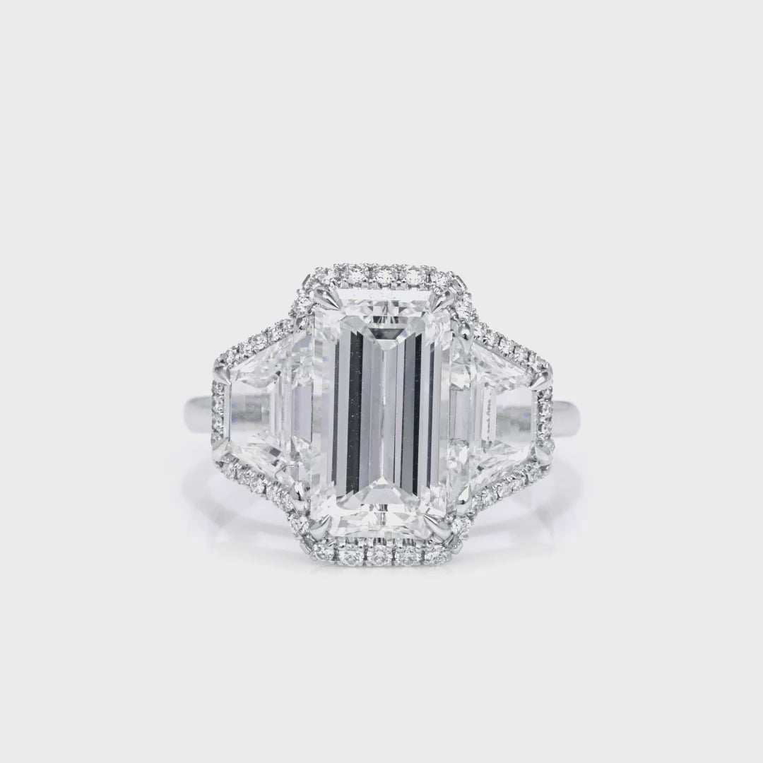Emerald Cut Diamond and Two Trapezoid Diamonds Halo Ring